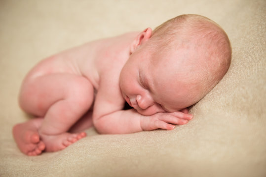 Newborn baby sleeps in the fetal position