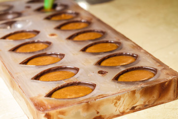 Filling out candy mold form with the chocolate