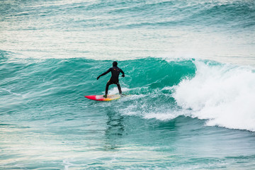 Surfing on turquoise wave in ocean