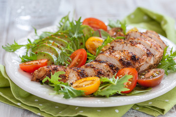 Healthy salad plate with colorful tomatoes, chicken breast and avocado