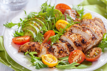 Healthy salad plate with colorful tomatoes, chicken breast and avocado