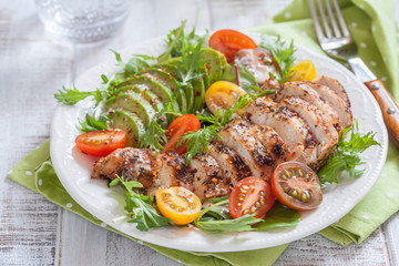 Healthy salad plate with colorful tomatoes, chicken breast and avocado