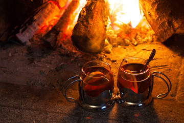 Two cups of tea near the fireplace
