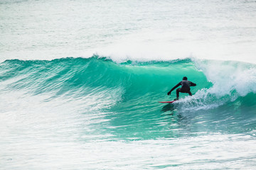 Surfing and beautiful blue wave in ocean.