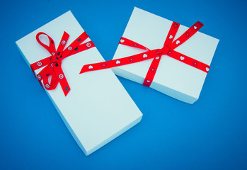 Two white gift boxes on blue background