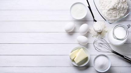 White background with baking tools and ingredients for cakes, top view, space for text.