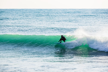 Surfing on turquoise wave in ocean