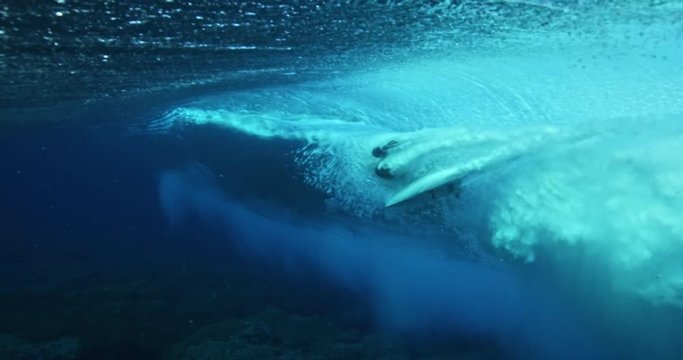 Underwater view of surfer riding ocean wave