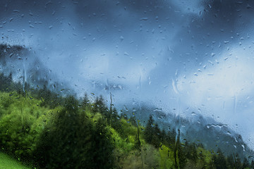 raindrops on a window with wooded mountains outside