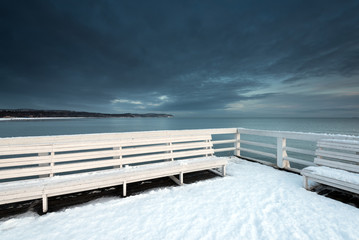 White bench on the pier. Early morning in winter time in Sopot, Poland. - obrazy, fototapety, plakaty