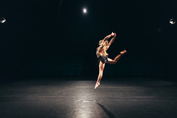 woman alone on stage doing modern dance performance