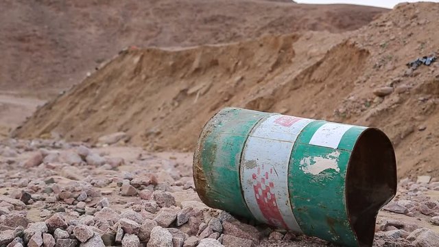 Iron barrel lies on the stony ground in Aqaba, Jordan