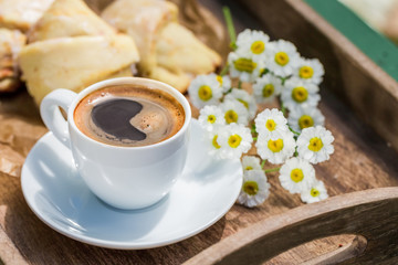 Hot coffee and delicious croissant for breakfast in garden