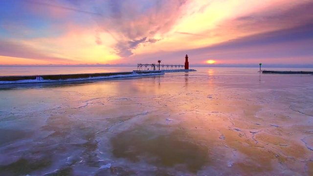Breathtaking low aerial tour of frozen Lake Michigan harbor Lighthouse.
