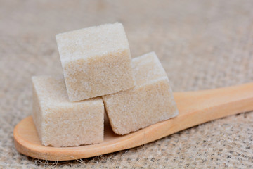 Wooden spoon with sugar cubes