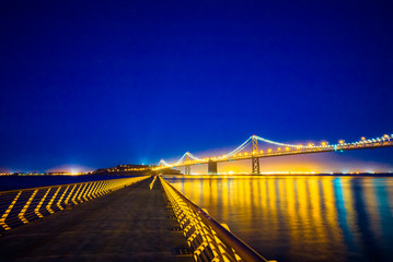 Fototapeta premium San Francisco Bay Bridge from Pier 14 at night with street lights