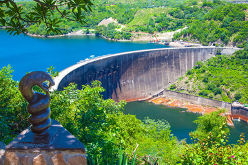 Lake Kariba dam wall and a statue of nyami nyami the river snake god.  Zambezi river.  Zimbabwe Africa. - obrazy, fototapety, plakaty