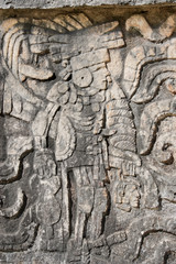 Fototapeta na wymiar Carving at Chichen Itza showing a winner at Mayan ball game carries loser's head