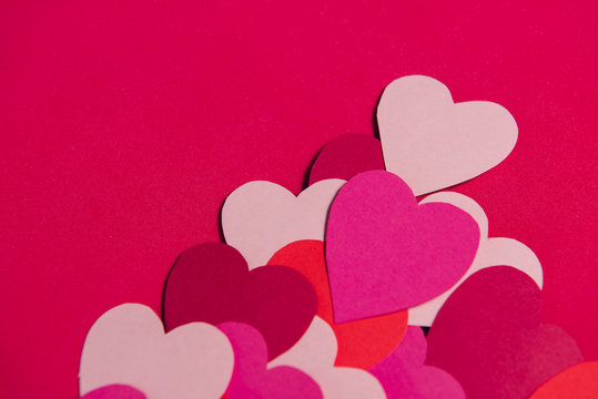 Beautiful paper hearts on red paper background, close-up