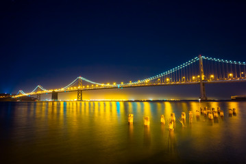 San Francisco Bay Bridge at Night.  Lights reflecting on the water.
