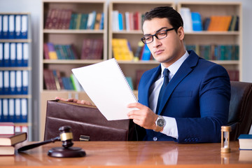 Handsome judge with gavel sitting in courtroom