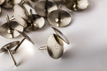 Gold drawing pins on a white background