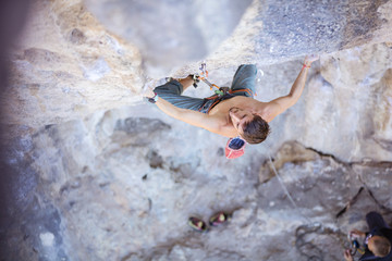 Male rock climber on a face of a cliff, view from above