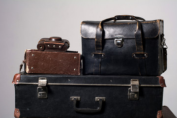 Stack of old shabby suitcase with a camera in bag