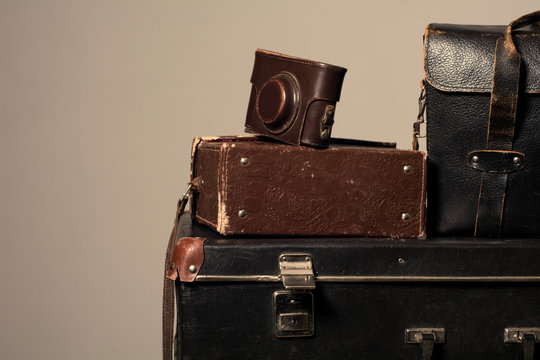 Stack of old shabby suitcase with a camera in bag