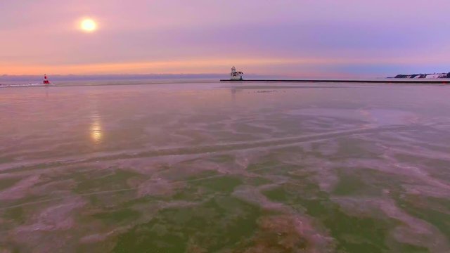 Breathtaking low aerial flight over subzero frozen Lake Michigan Lighthouse.
