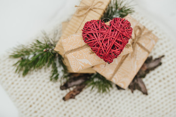 The Valentines day concept. Valentines gifts, vintage romantic red heart gifts boxes, tree branches and bark of tree lie on a woolen blanket background. Winter theme. Top view. Free space.