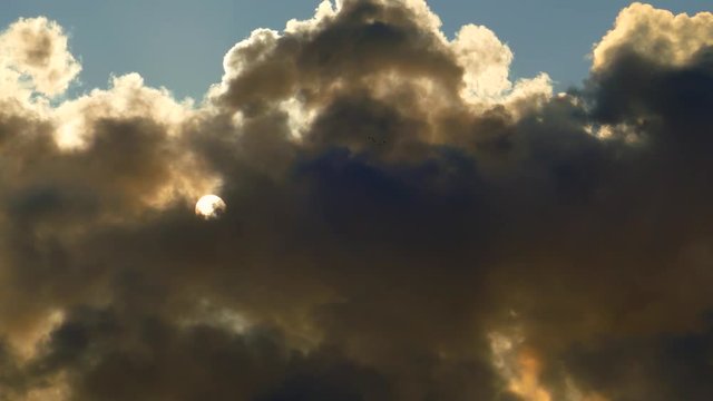 Sun changes shape and is distorted as it squeezes through thick clouds of factory emissions.
