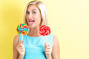 Young woman holding lollipops