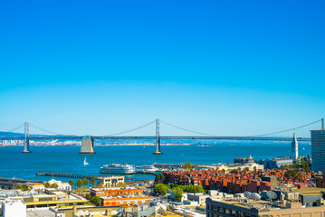 Obraz premium Day time view of San Francisco's Bay Bridge and the downtown Ferry Building area.