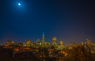 San Francisco cityscape and a full moon at night, taken from Coit Tower.  Downtown and the financial district