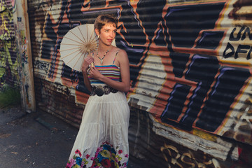 Young caucasian woman wearing bohemian skirt and top in a grungy, urban location