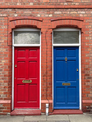 a blue and red door next to each other in a classic English building in cherster, England