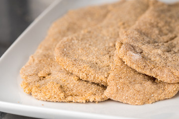 Closeup of breaded meat slices, raw before the steaks are put in a frying pan