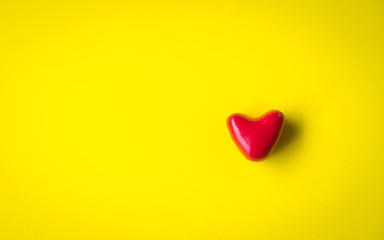 man hands giving red heart on yellow background