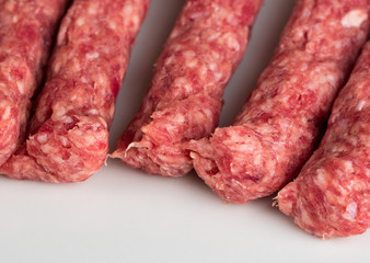 Raw kebabs on white background, quality minced meat special