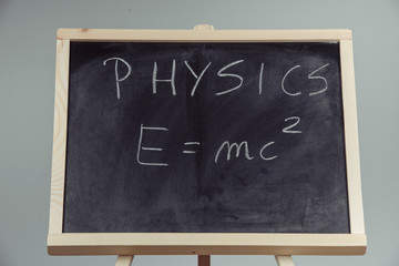 Physics word and formula E=mc2 on chalkboard