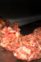 Tasty meat special, minced meat balls with spicy seasoning and bits of onion and bacon