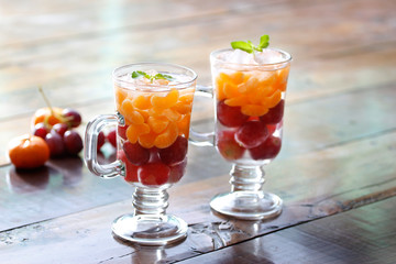 Glass refreshing detox diet drinks of mix fruits on wooden background
