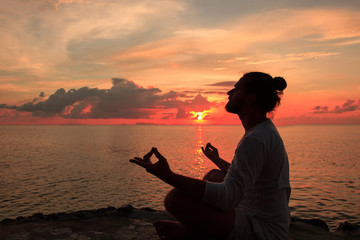 Yoga scene silhouette in sunset.