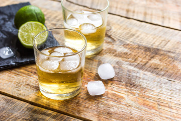 glass of whiskey on wooden background