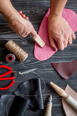 work in leather shop on dark wooden background top view