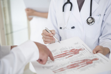 The doctor explains to the patient using the human body model drawing