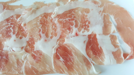 close-up sliced raw fresh meat on white plate for barbecue or shabu from fresh market 