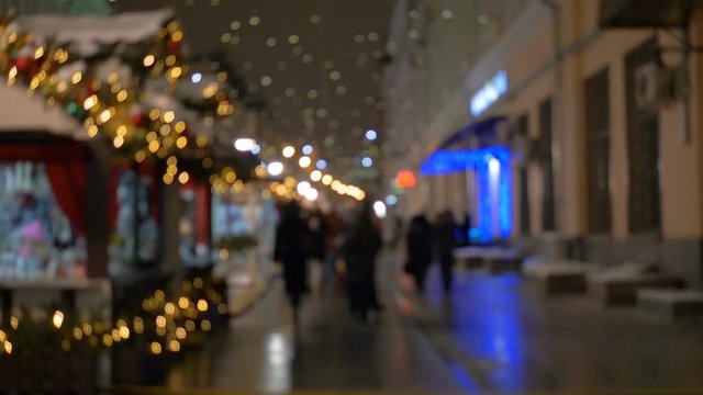 People walking on the street in the evening, a festive illumination, out of focus