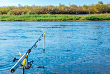 Fishing rod fisherman on supports on a background of water
